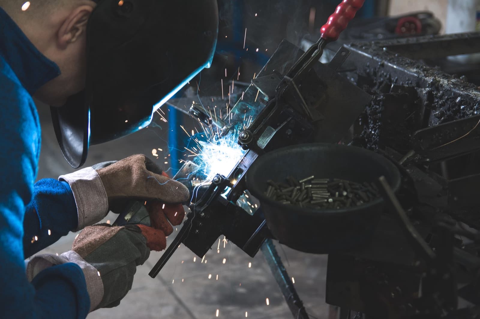 Industrial welder working on a metal component